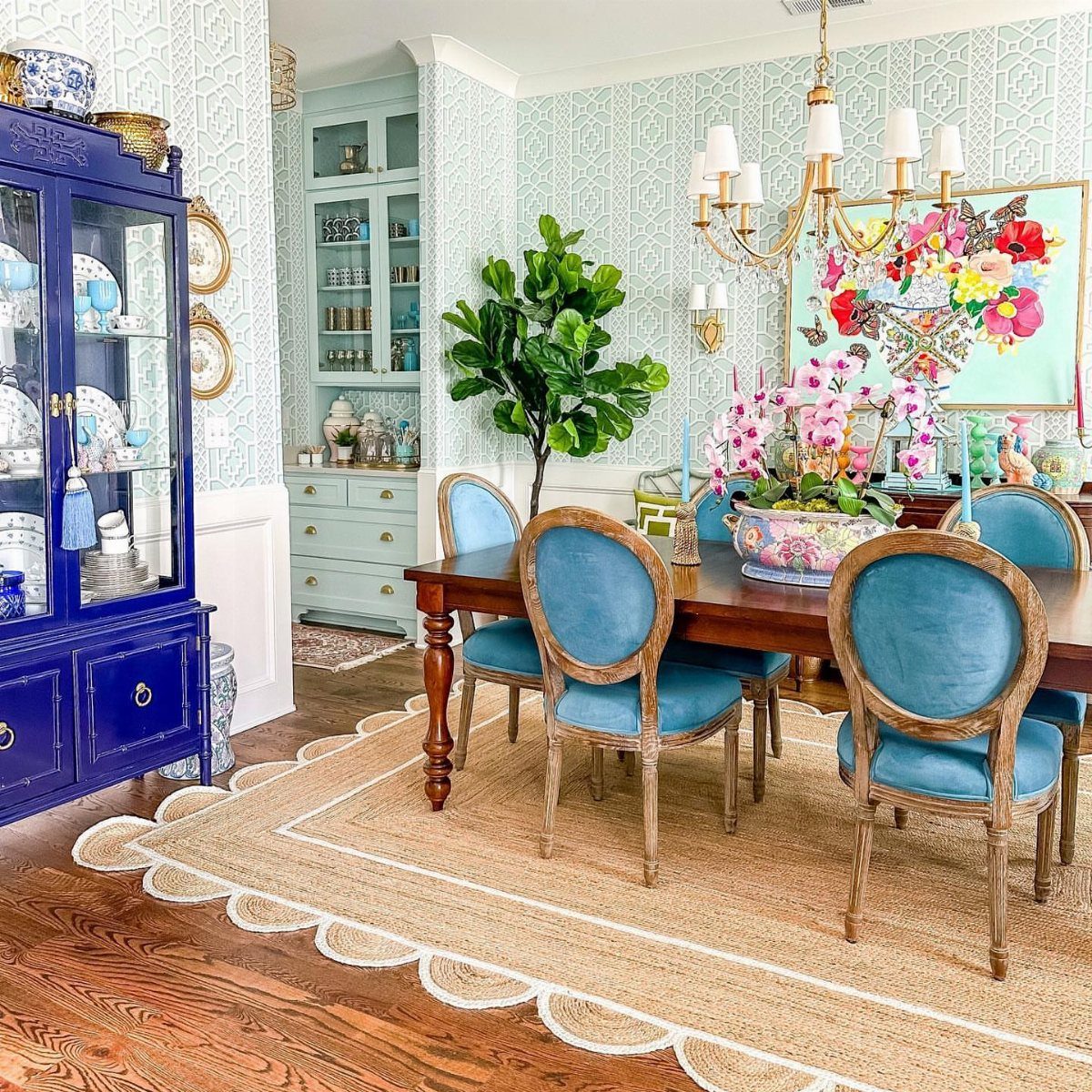 Dining room with blue chairs and hutch coordinated with a natural scalloped rug.
