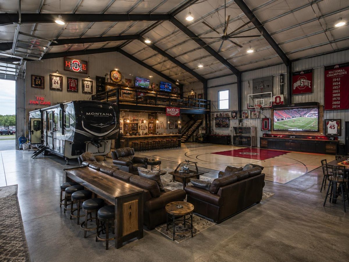 A large garage converted into a luxury man cave with leather seating and sports memorabilia.