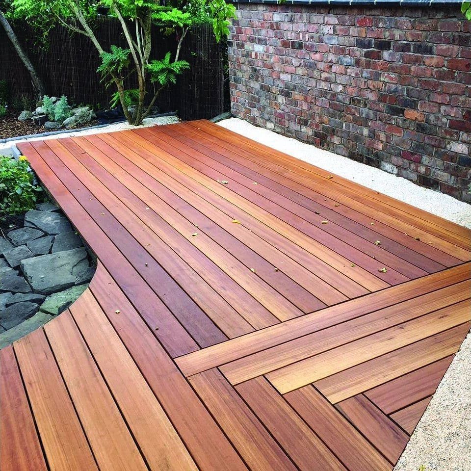 Wooden deck planks arranged in a decorative herringbone pattern with reddish-brown stains.