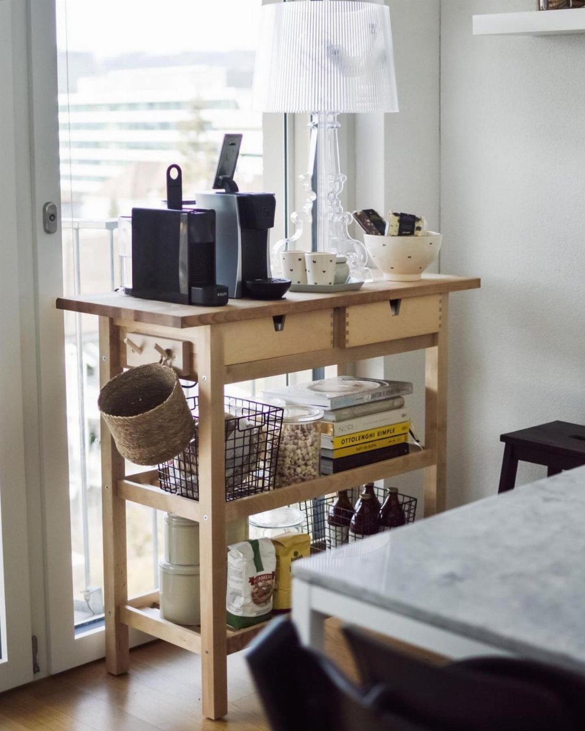 Wooden kitchen storage trolley with coffee station and organized lower shelves.