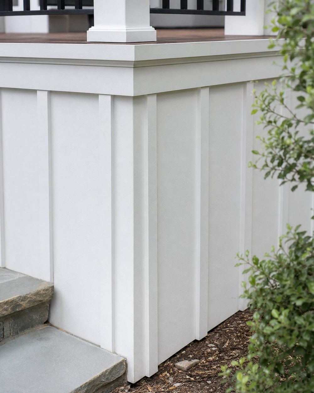 White vertical board and batten skirting installed on the base of a modern outdoor deck.