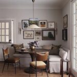 Tan velvet dining chairs with black frames around a round wooden dining table.