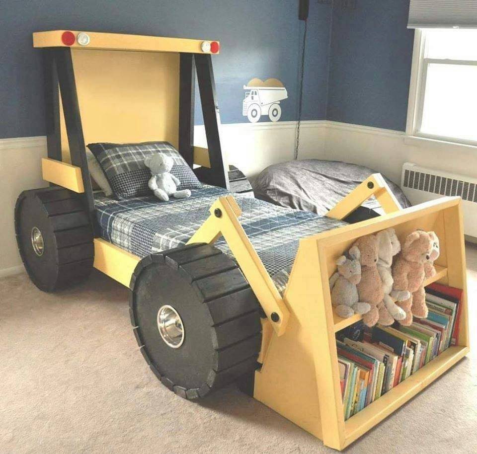 Tractor shaped bed with large black wheels and built-in bookshelf in blue bedroom